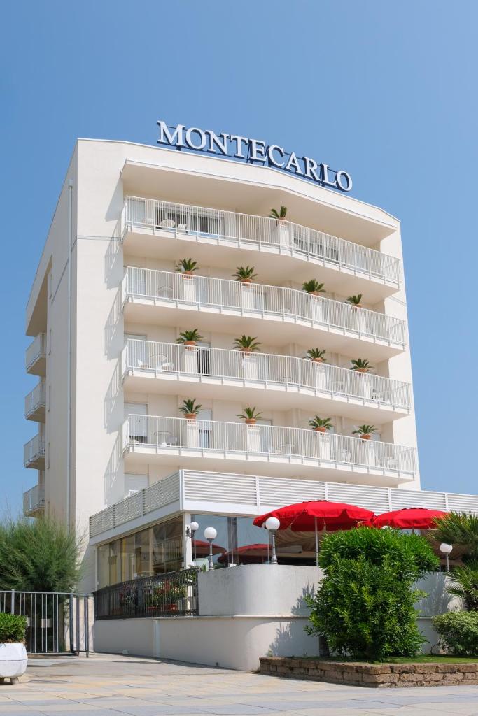 un bâtiment blanc avec un panneau dessus dans l'établissement Hotel Montecarlo, à Lido di Jesolo
