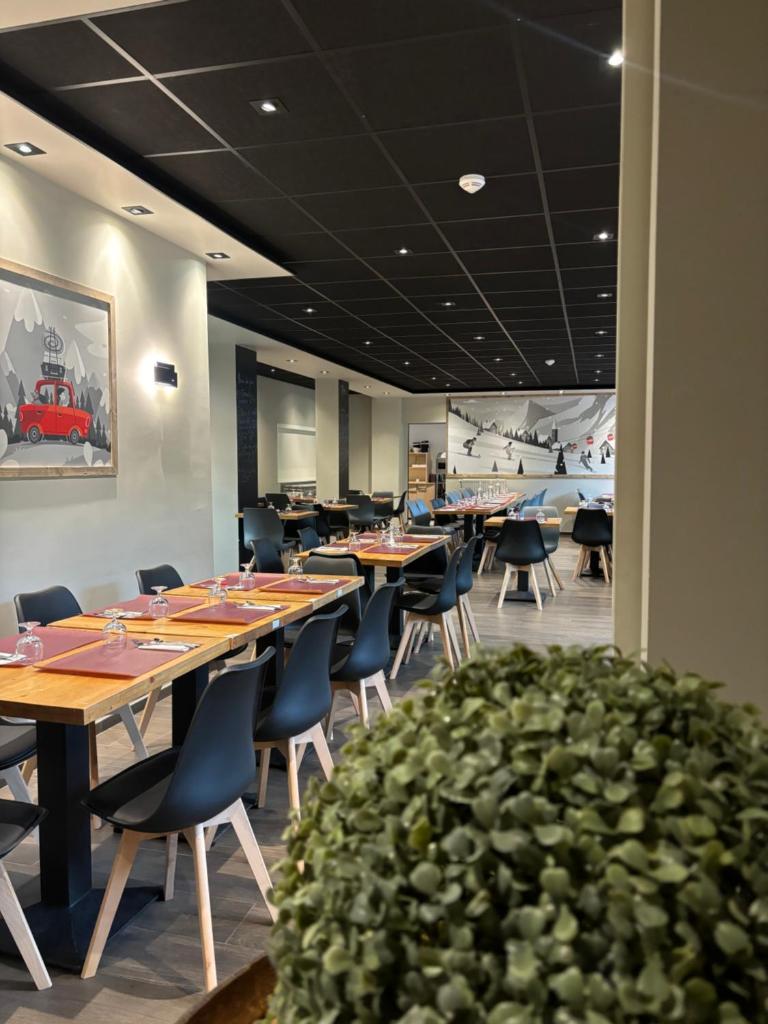 un restaurant avec des tables et des chaises en bois et une plante dans l'établissement Chalet Sainte Anne, à Condamine-Châtelard