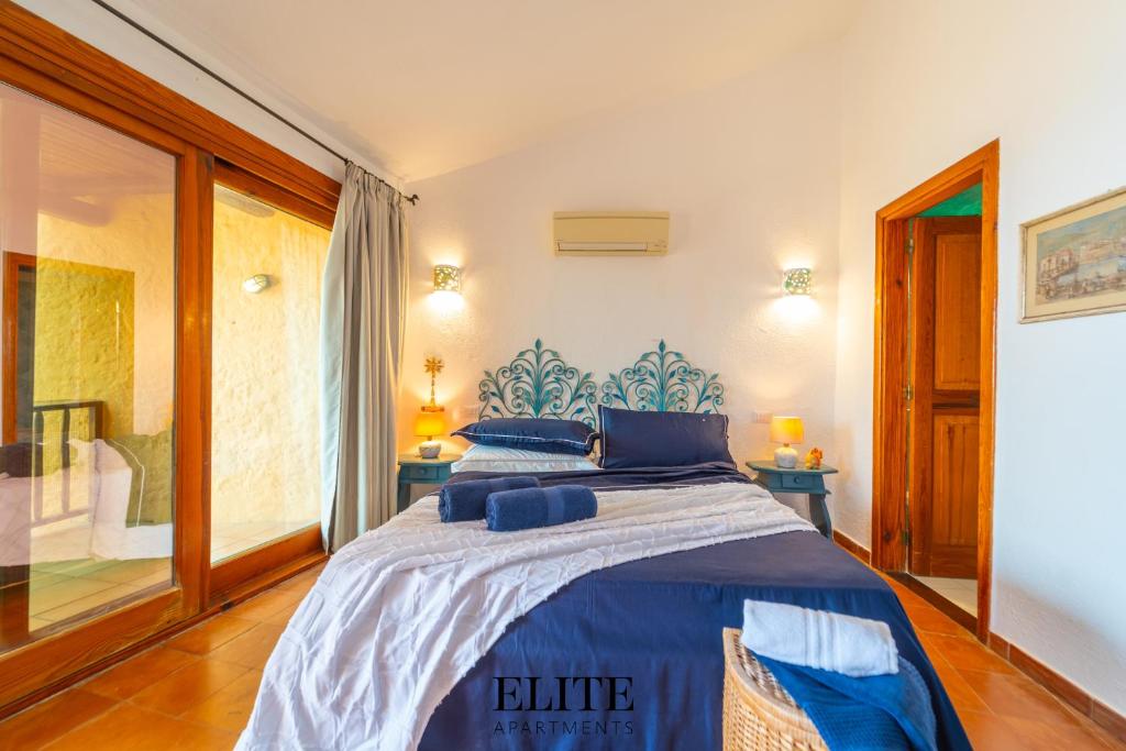 une chambre avec un lit avec des draps bleus et une fenêtre dans l'établissement Villa sul Golfo del Pevero con accesso a mare, à Porto Cervo 50 autres photos
