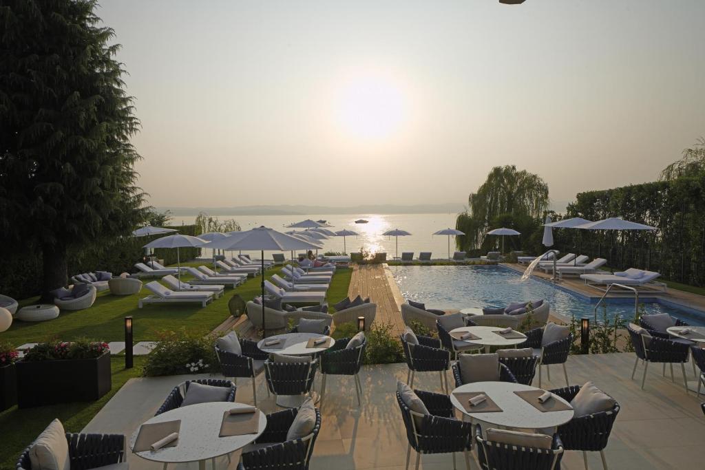 - une rangée de tables et de chaises à côté de la piscine dans l'établissement Hotel Unico by Dori, à Sirmione