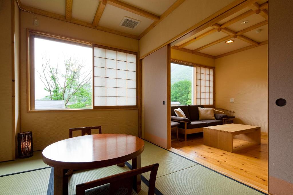 un salon avec une table et un canapé dans l'établissement Miyama Ouan Kyoritsu Resort, à Takayama