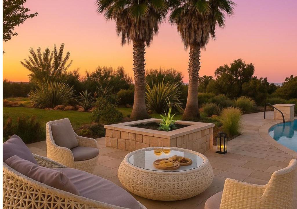 un patio avec une table et des chaises et une piscine dans l'établissement Villa Flavia, à Polignano a Mare