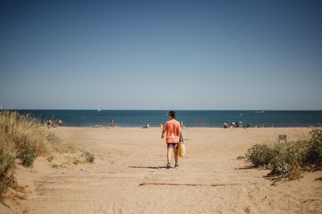 Un homme se promène sur la plage dans l'établissement Domaine Les Mûriers, à Vendres-Plage