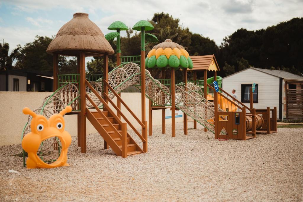 une aire de jeux avec un tas de différents types d'équipements de jeux dans l'établissement Domaine Les Mûriers, à Vendres-Plage