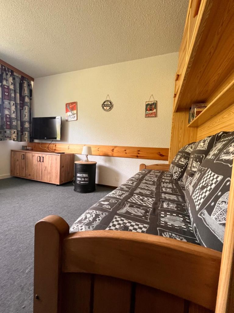 une chambre avec un lit et une télévision à écran plat dans l'établissement Studio de la Marmotte - Aime 2000, à Aime La Plagne