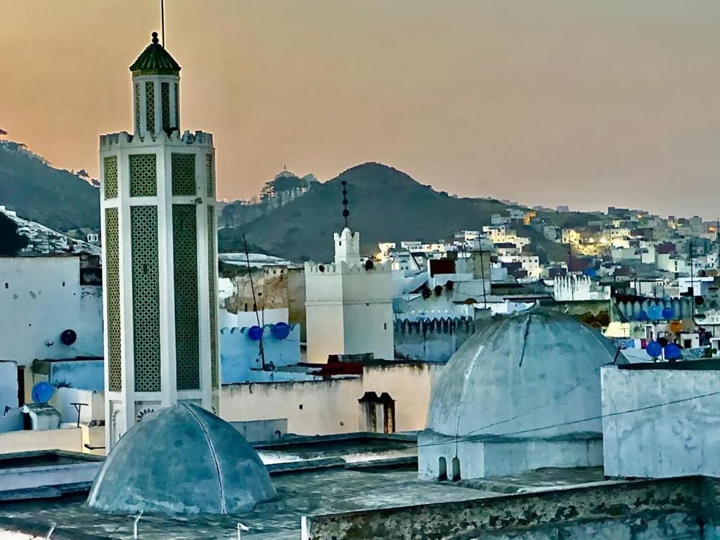 - une vue sur une ville avec une tour de l'horloge et des bâtiments dans l'établissement Riad EL Manantial,Dar Hajjaj,Patrimonio del SXIX, à Tetouan