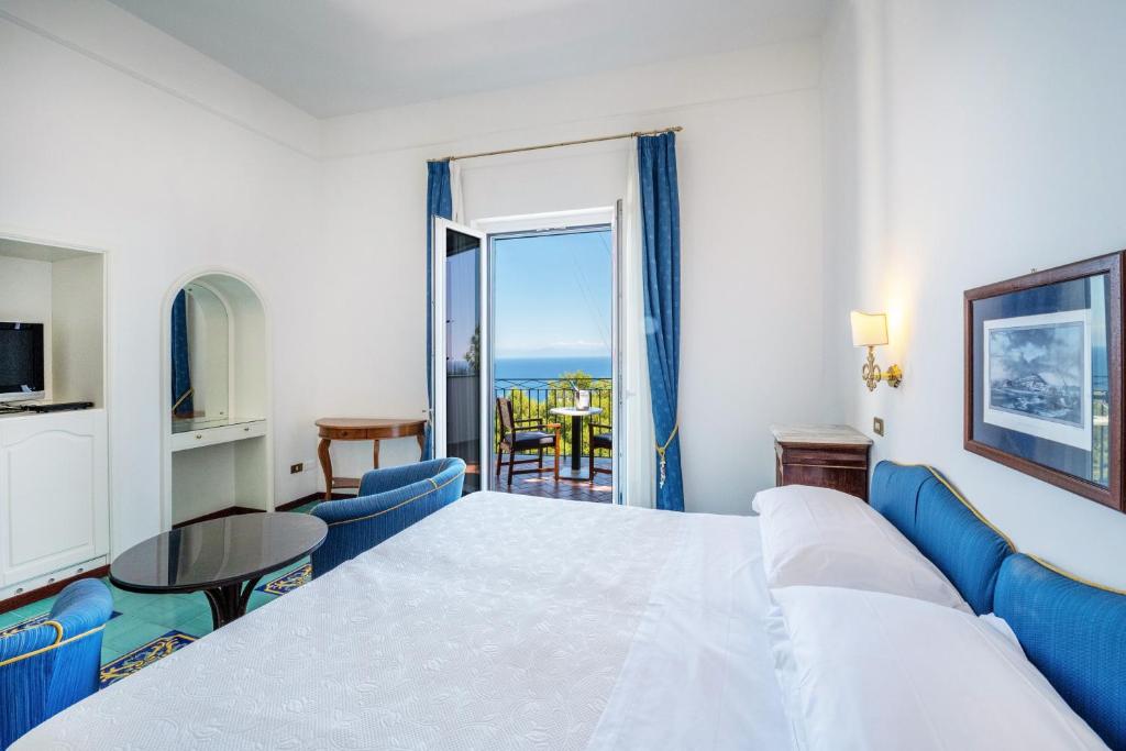une chambre d'hôtel avec un lit et une vue sur l'océan dans l'établissement Hotel Belvedere, à Conca dei Marini