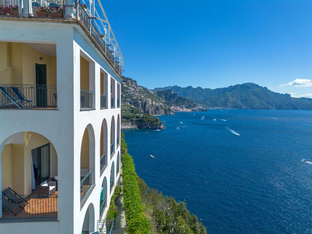 - un bâtiment avec vue sur une étendue d'eau dans l'établissement Hotel Belvedere, à Conca dei Marini