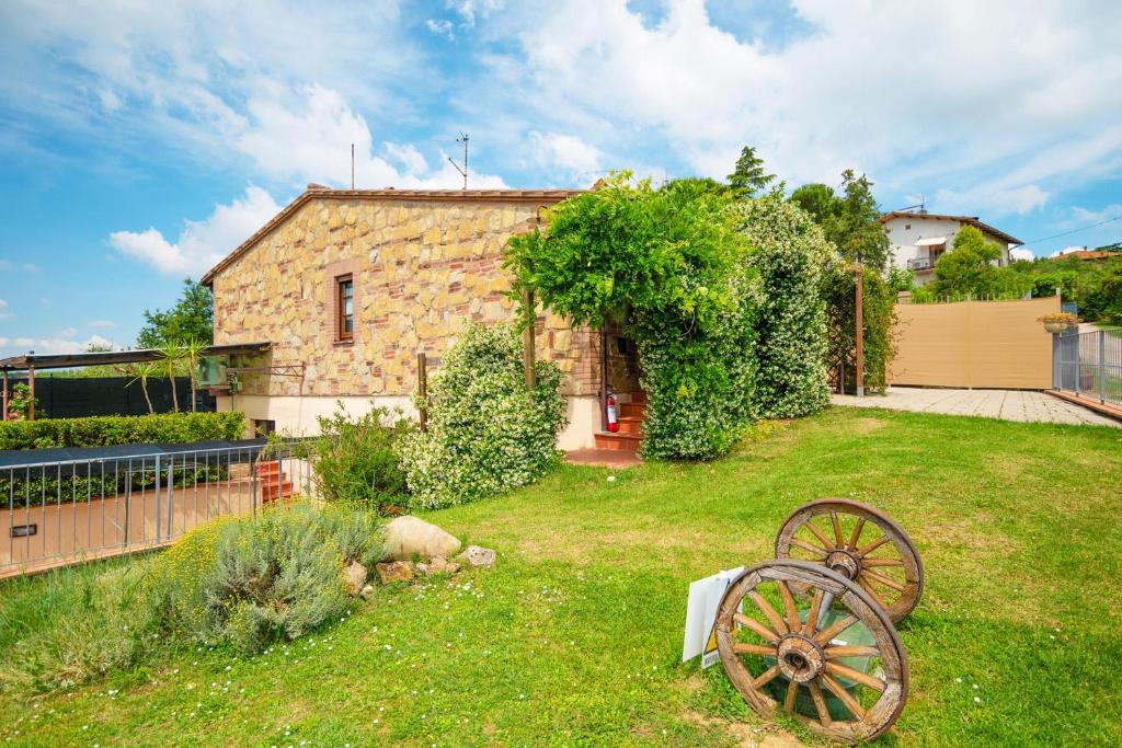 une maison en pierre avec une roue dans une cour dans l'établissement La Casa Del Sole, à Casamaggiore