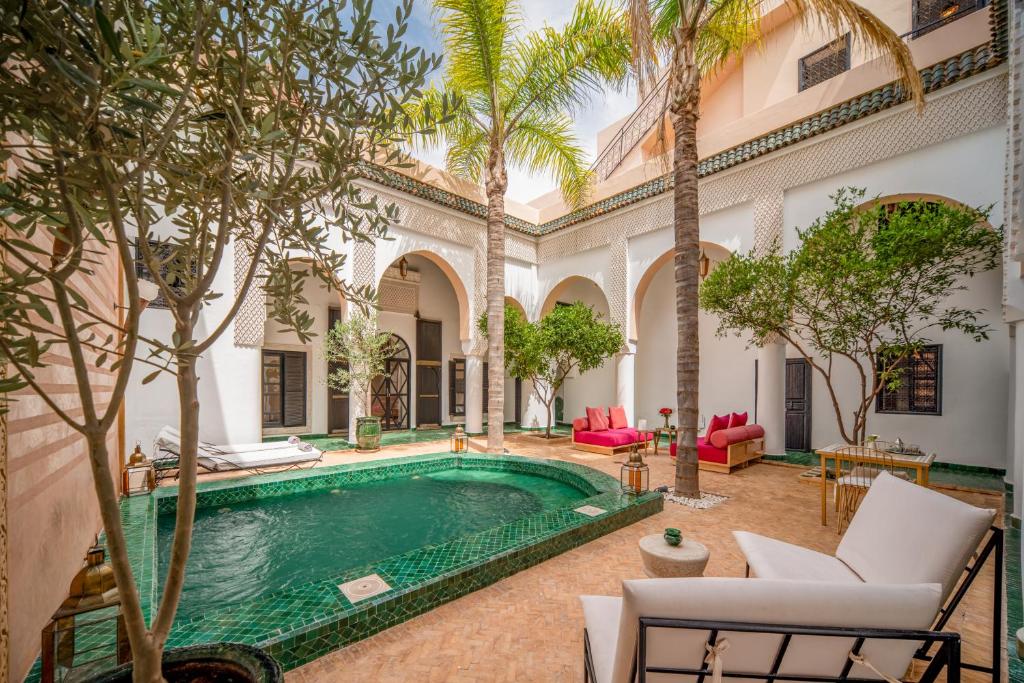 une piscine intérieure dans une cour avec des palmiers dans l'établissement Riad Akasia, à Marrakech 37 autres photos