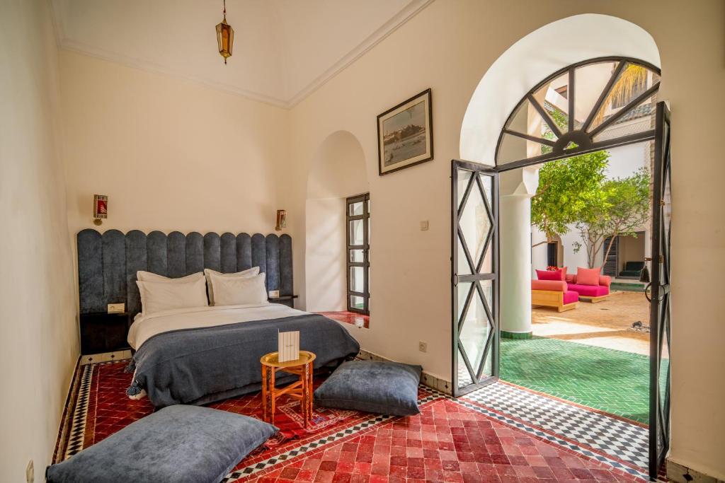 - une chambre avec un lit et une porte voûtée dans l'établissement Riad Akasia, à Marrakech
