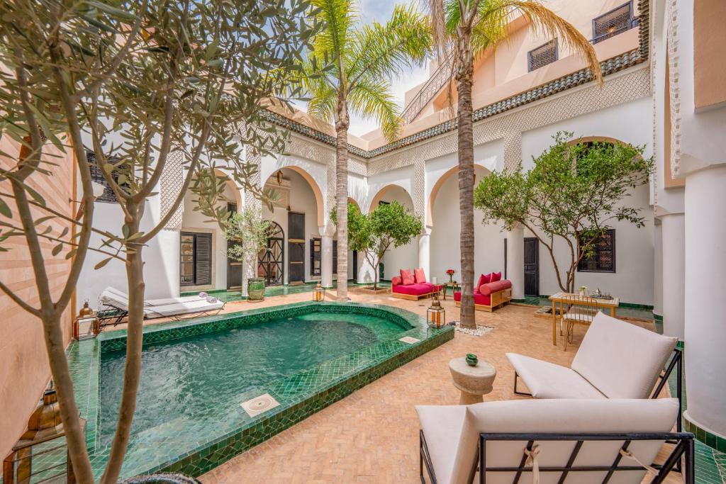 une piscine intérieure dans une cour avec des palmiers dans l'établissement Riad Akasia, à Marrakech