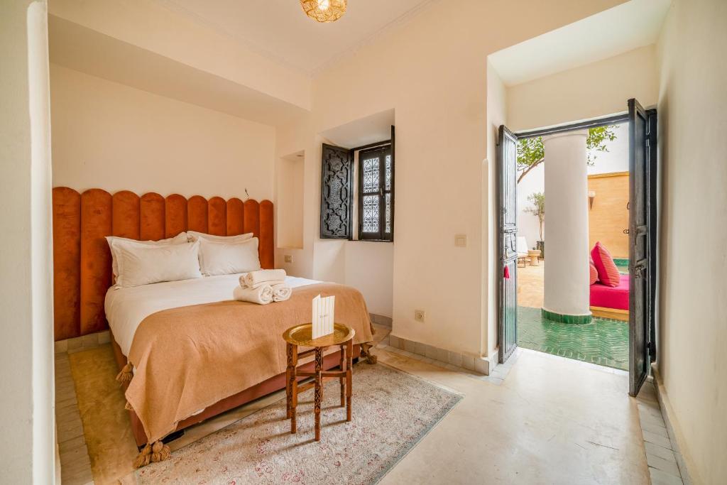 une chambre avec un grand lit et une table dans l'établissement Riad Akasia, à Marrakech