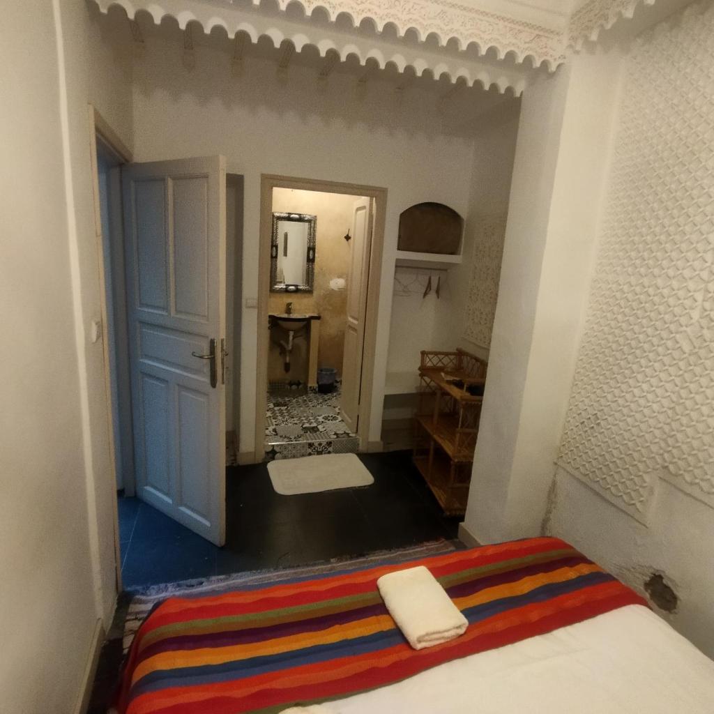 - une chambre avec un lit, une porte et un miroir dans l'établissement Diamant La Ville Rouge, à Marrakech