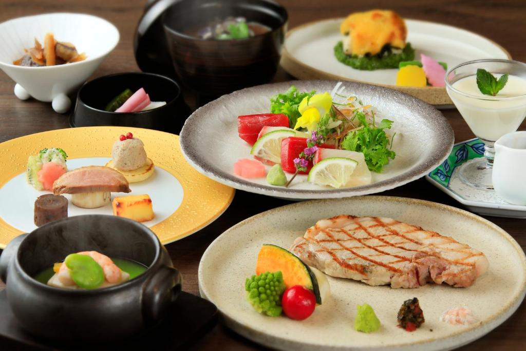 une table en bois avec des assiettes de nourriture dans l'établissement Oarai Park Hotel, à Ōarai