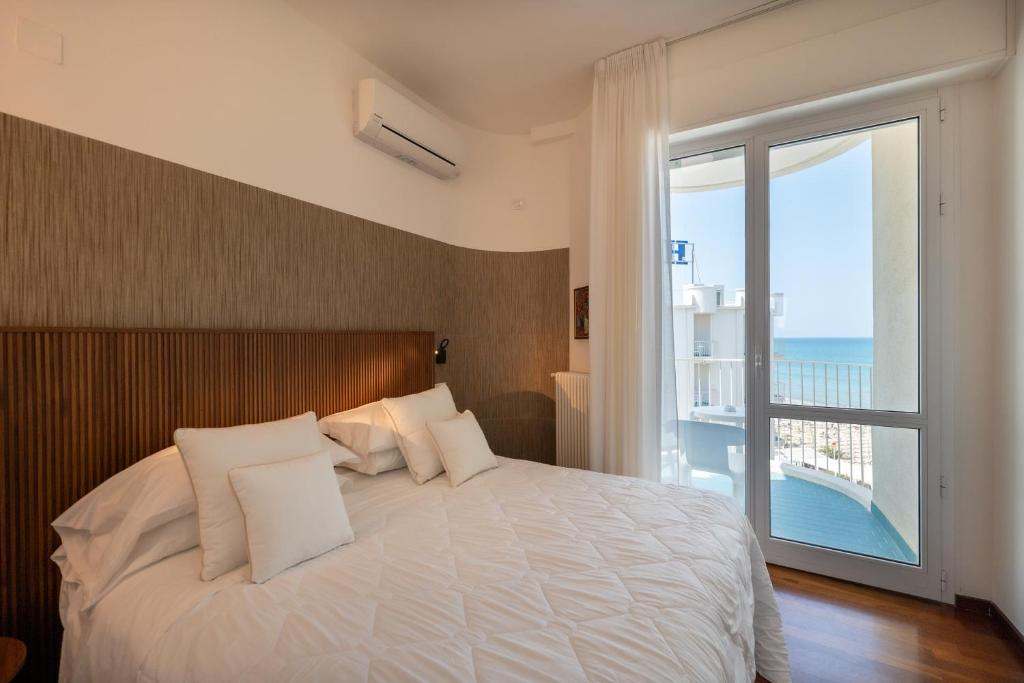 une chambre avec un grand lit et une grande fenêtre dans l'établissement HR Resort, à Senigallia 93 autres photos