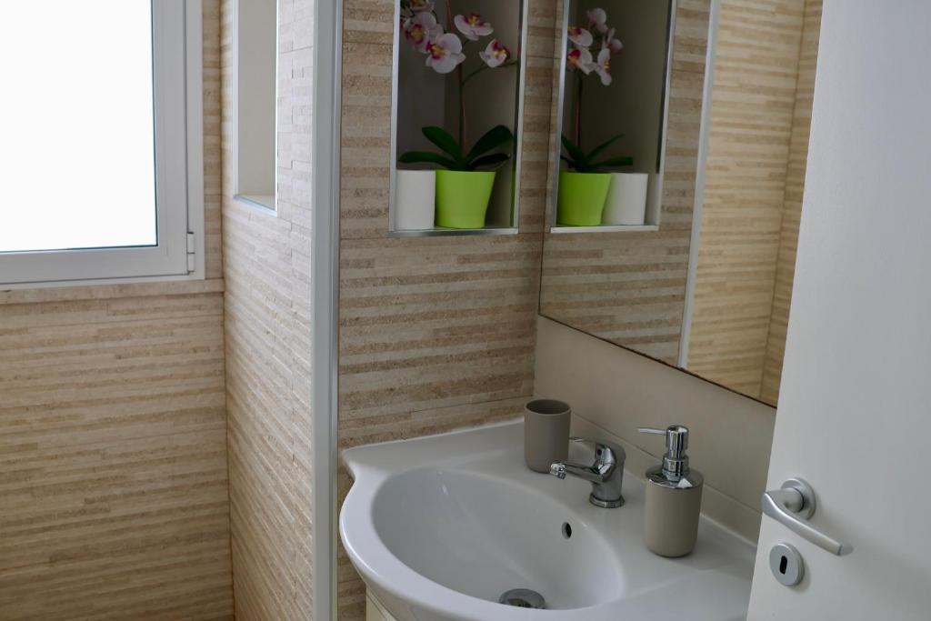 une salle de bain avec un lavabo et un miroir dans l'établissement Villa Zoe, à Comiso