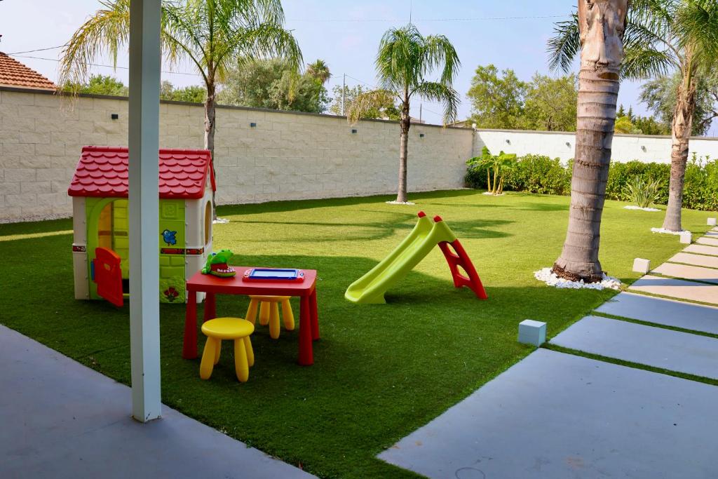 une cour avec une aire de jeux avec une table et un toboggan dans l'établissement Villa Zoe, à Comiso