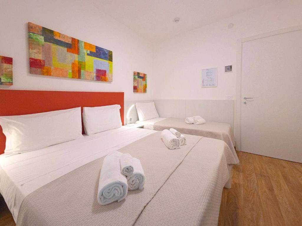 une chambre avec deux lits avec des serviettes dessus dans l'établissement Hotel Royal Garnì, à Caorle