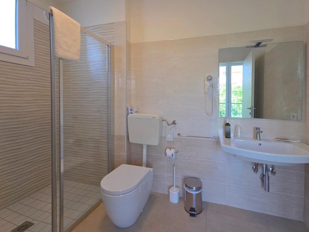 une salle de bain avec toilettes, lavabo et douche dans l'établissement Hotel Royal Garnì, à Caorle