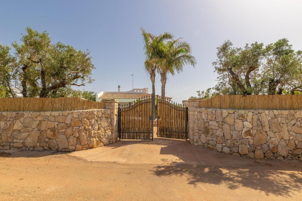 une porte avec une clôture en pierre et un mur en pierre dans l'établissement Villa Aurelio, à Capilungo