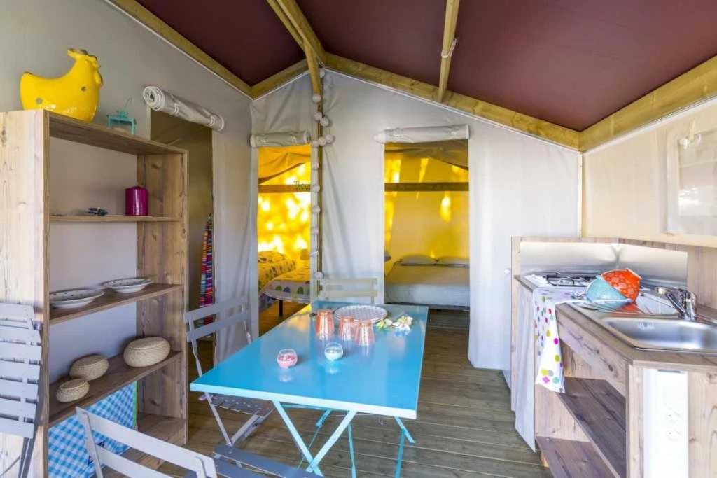 - une cuisine avec une table bleue dans une pièce dans l'établissement Camping 4 étoiles - Piscine - ccbahea, à Lansargues