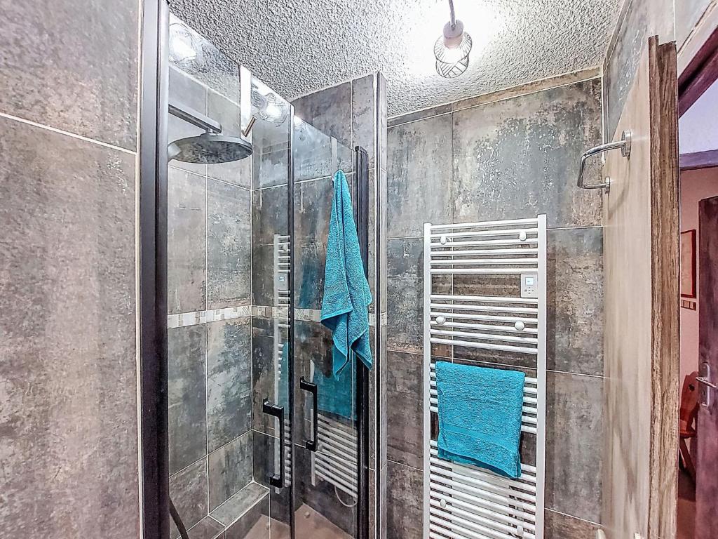 une douche avec une porte vitrée dans une salle de bain dans l'établissement Apartment Bâtiment A-18 by Interhome, au Corbier