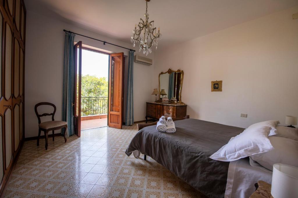 une chambre avec un lit, un miroir et une fenêtre dans l'établissement Casa del carrubo, à Carini