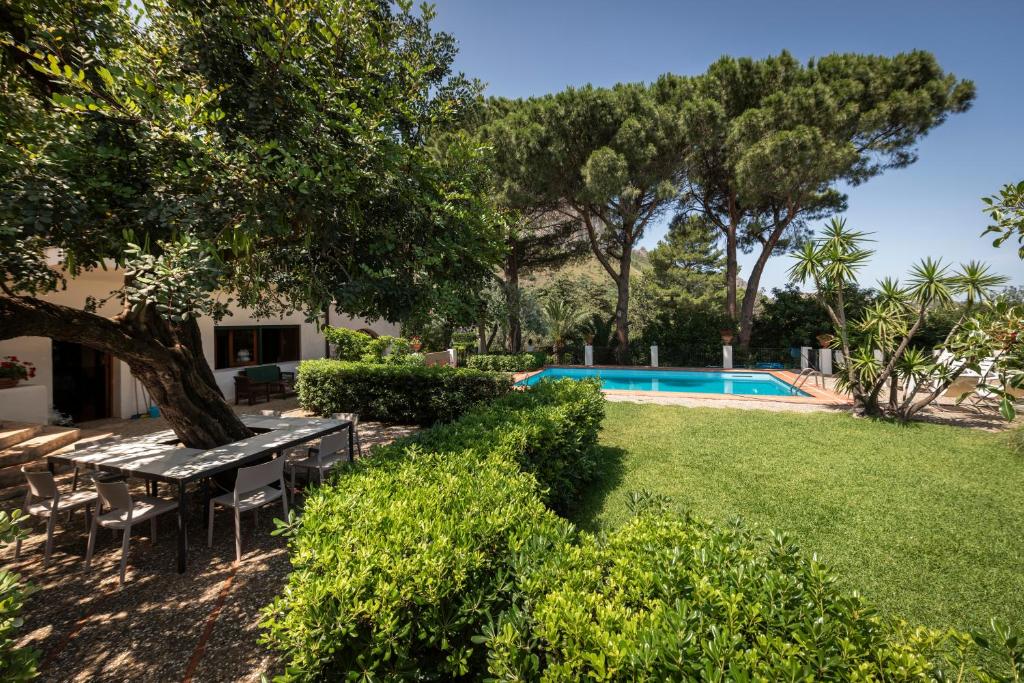 un jardin avec une table de pique-nique et une piscine dans l'établissement Casa del carrubo, à Carini