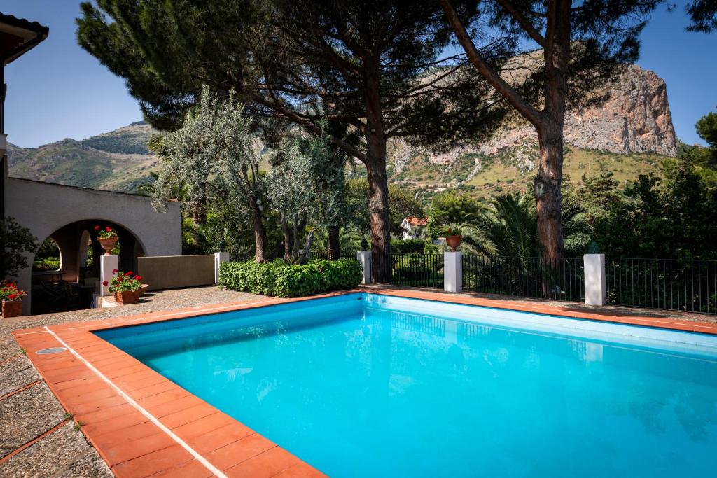 une piscine bleue avec une montagne en arrière-plan dans l'établissement Casa del carrubo, à Carini