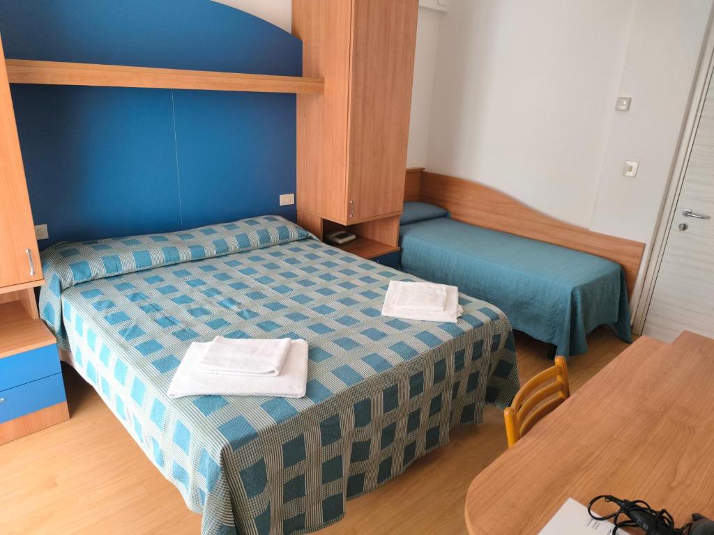 une petite chambre avec deux lits et une table dans l'établissement Hotel Midi, à Lido di Jesolo 34 autres photos