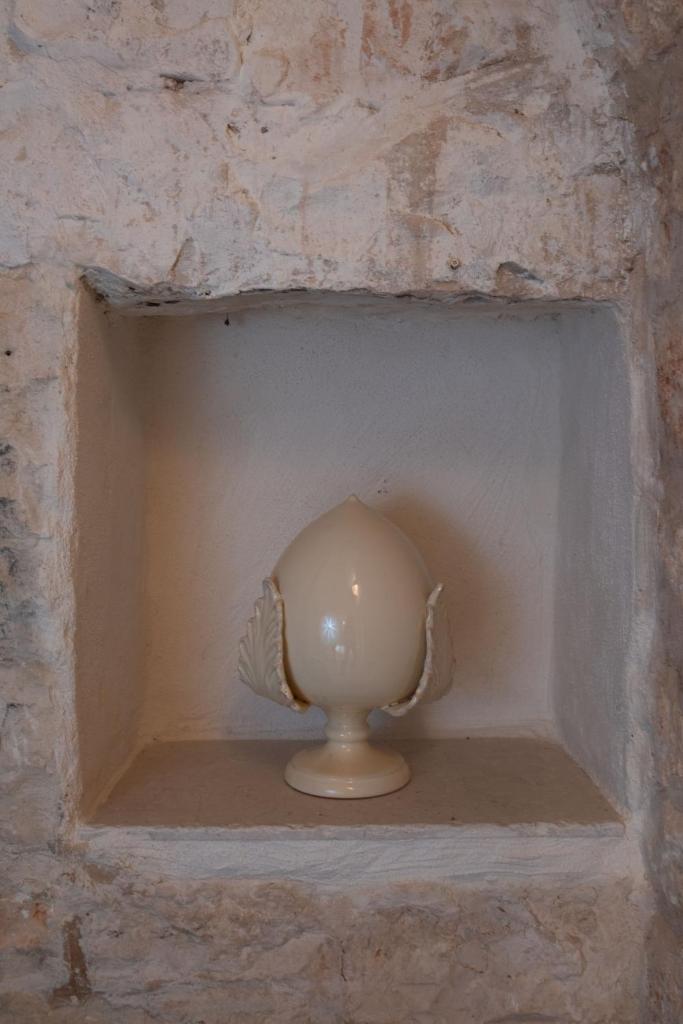 un vase blanc dans une niche dans un mur de briques dans l'établissement Trullo Alba, à Cisternino 32 autres photos