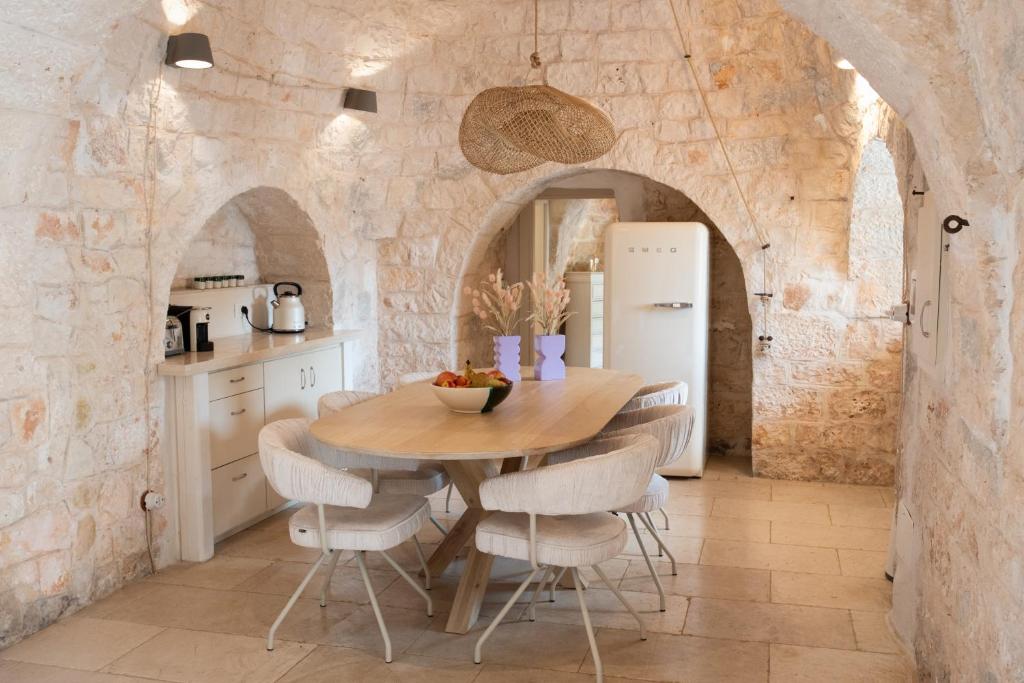 une cuisine et une salle à manger avec une table et des chaises en bois dans l'établissement Trullo Alba, à Cisternino