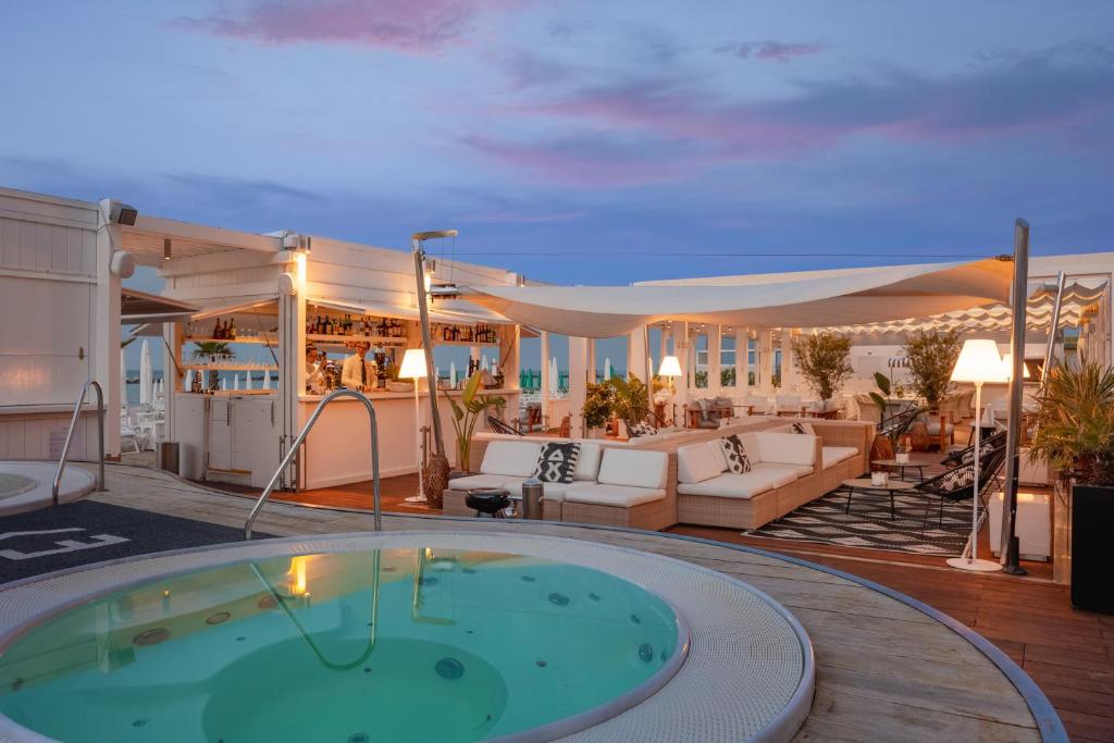 un patio avec un bain à remous sur une terrasse dans l'établissement Excelsior Hotel, SPA & Lido - Preferred Hotels & Resorts, à Pesaro