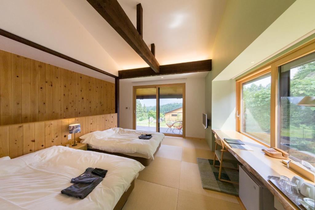 deux lits dans une chambre avec un comptoir et un lavabo dans l'établissement Satoyama Jujo, à Minami Uonuma