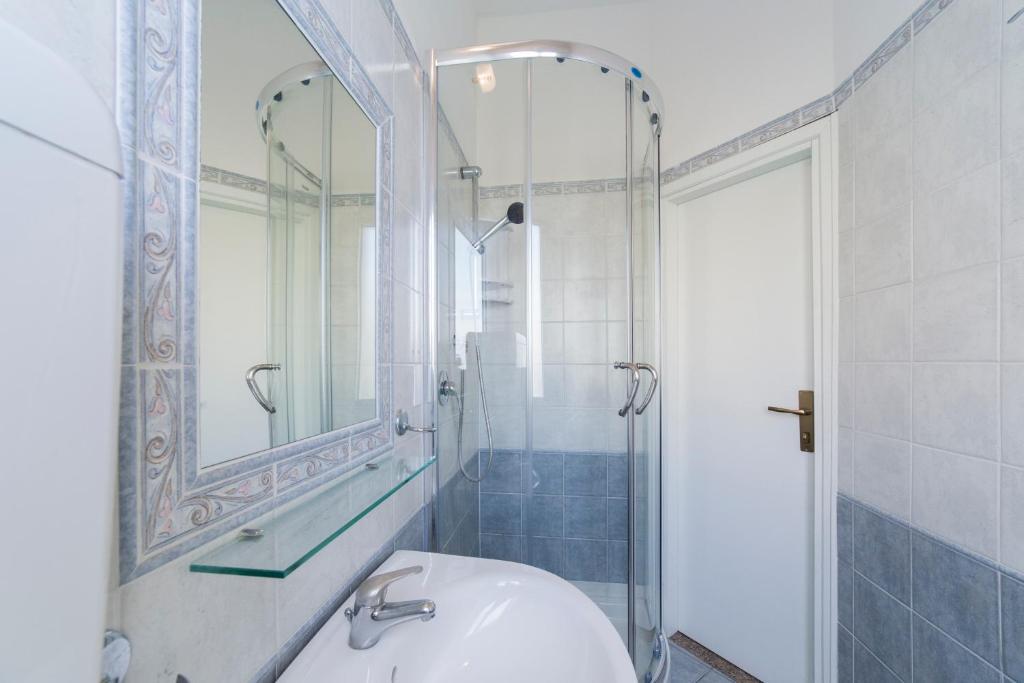 une salle de bain blanche avec un lavabo et un miroir dans l'établissement Hotel Europa, à Rimini