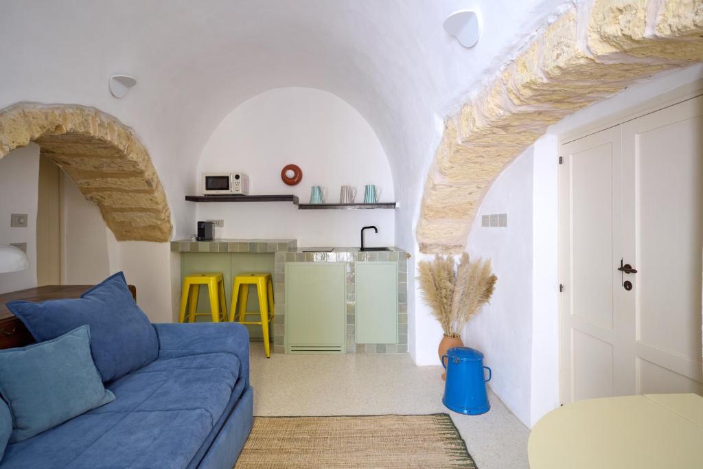 un salon avec un canapé bleu et une cuisine dans l'établissement Dimore Arcudi, à Galatina