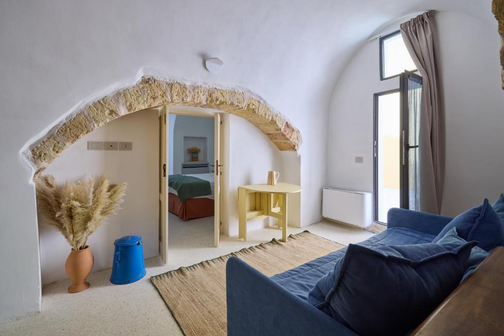 un salon avec un canapé bleu et une chambre dans l'établissement Dimore Arcudi, à Galatina
