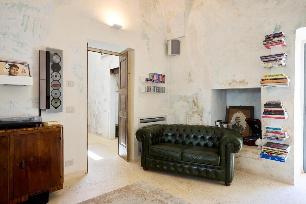 - un salon avec un canapé en cuir vert et une cheminée dans l'établissement Dimore Arcudi, à Galatina
