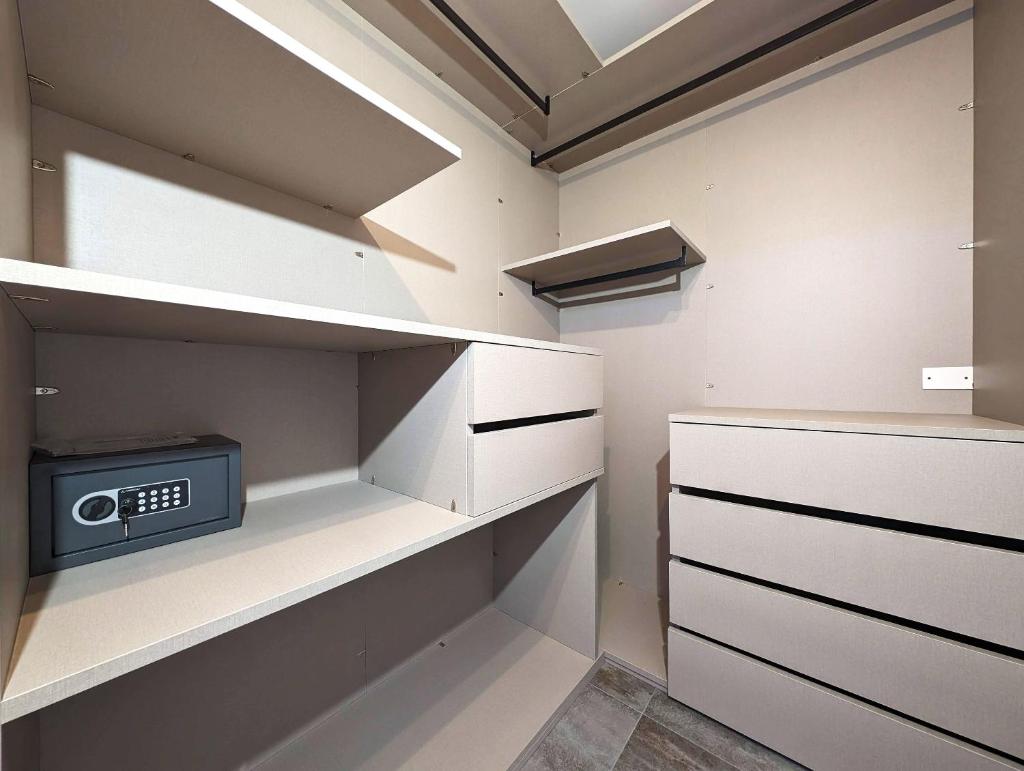 un dressing avec une horloge sur l'étagère dans l'établissement Villa con piscina e SPA nel Salento Alternative Relax, à Scorrano