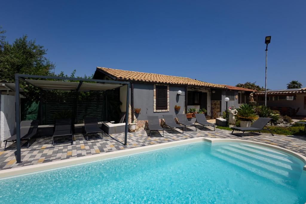 une piscine avec des chaises et une maison dans l'établissement Gulliver's Nest, à Castellammare del Golfo