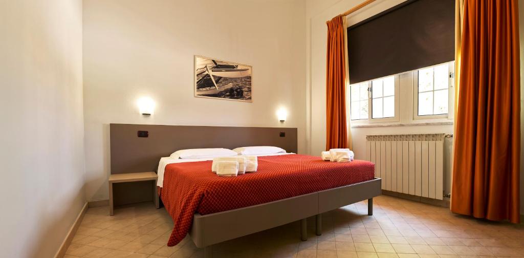 une chambre avec un lit avec une couverture rouge dans l'établissement Oasi del Mare, à Tirrenia