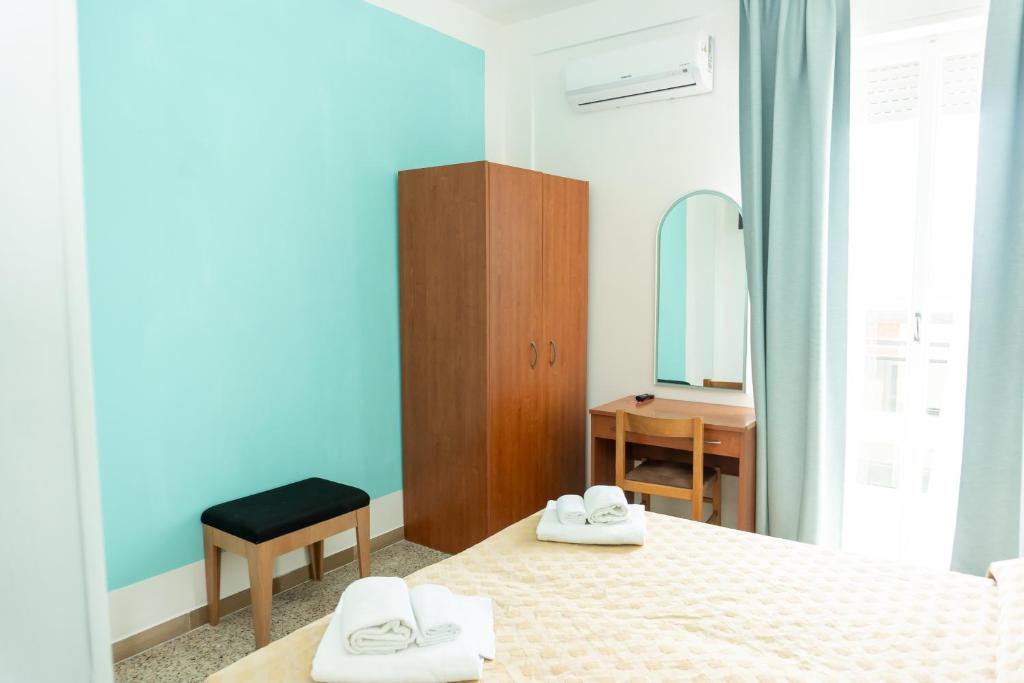 une chambre avec un lit et un miroir dans l'établissement Hotel Gin sul mare, à Rimini