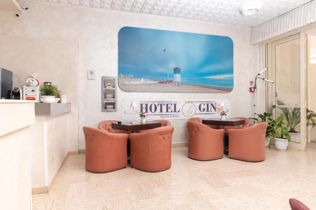 une chambre avec deux chaises et un grand écran dans l'établissement Hotel Gin sul mare, à Rimini