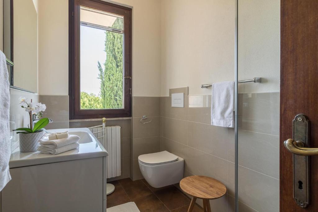 une salle de bain avec un lavabo et des toilettes et une fenêtre dans l'établissement Villa Stefano by Garda FeWo, à Soiano del Lago