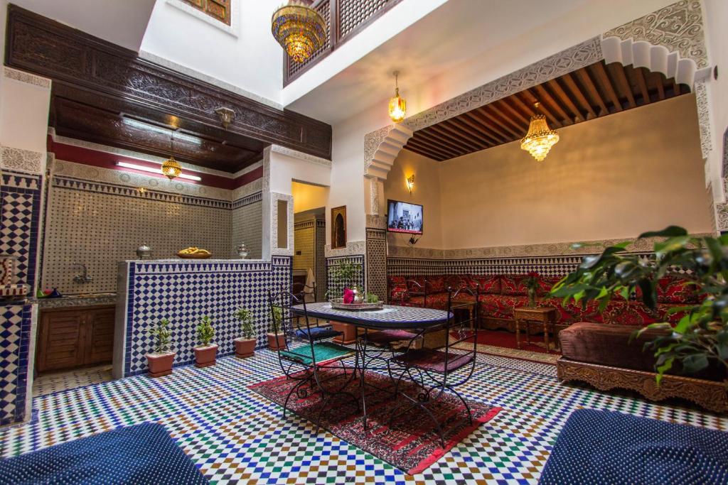 un hall d'entrée avec une table, des chaises et un canapé dans l'établissement Dar El Mathaf, à Fès