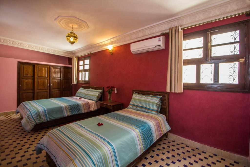 - 2 lits dans une chambre aux murs rouges dans l'établissement Dar El Mathaf, à Fès