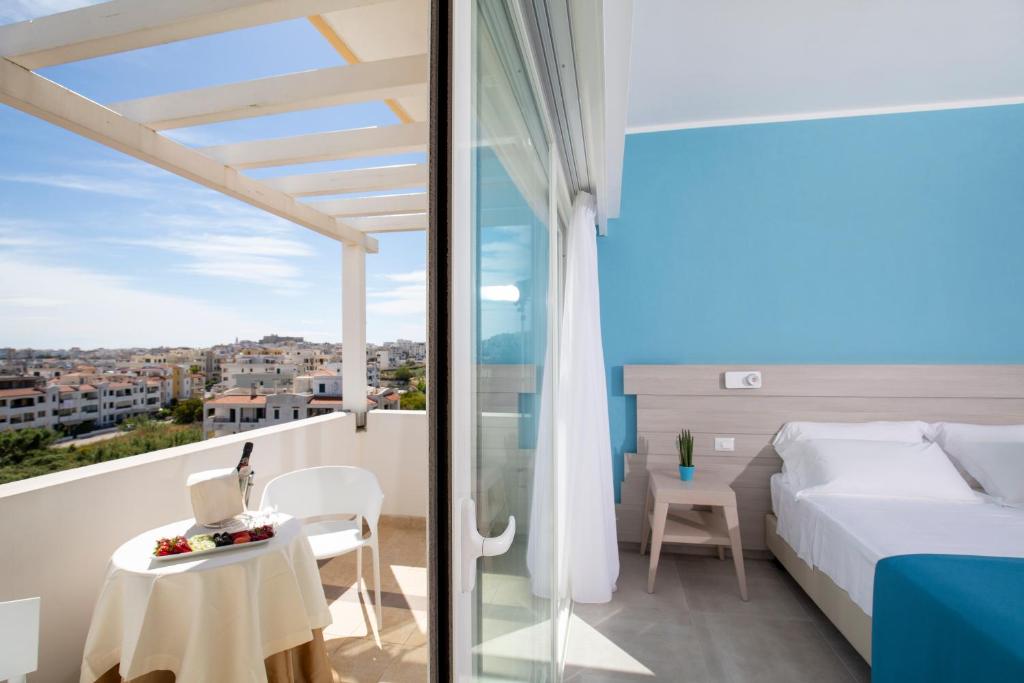 une chambre avec un lit et une table dans l'établissement Hotel I Melograni, à Vieste