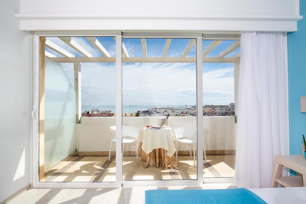 Cette chambre dispose d'une table et d'un balcon avec vue. dans l'établissement Hotel I Melograni, à Vieste