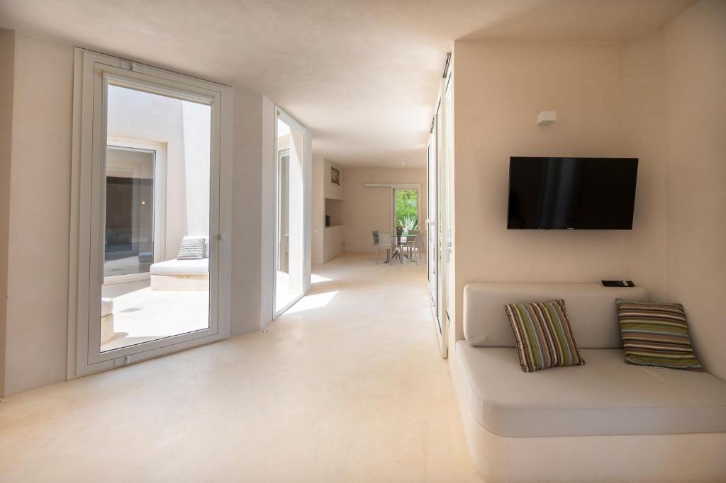 - un salon avec un canapé et une télévision murale dans l'établissement Sky Dream Oasi Vendicari - Sicilia Vacanza, à Casa Maccari